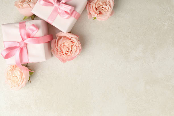 istock Gift boxes and roses on white textured background, space for text 1300358361