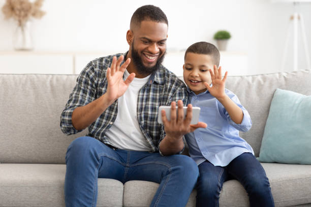 istock African Father And Son Using Phone Video Calling At Home 1300358402