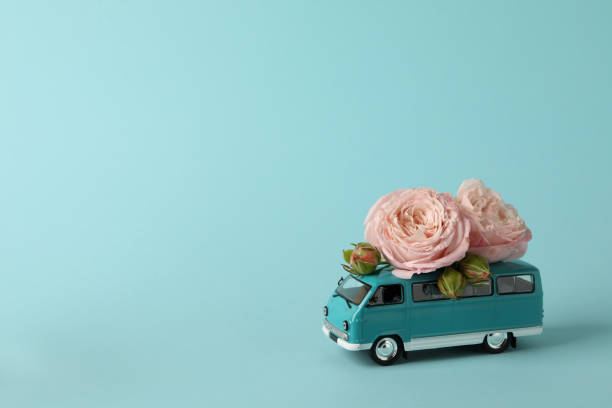 istock Toy bus with pink roses on blue background 1300358665