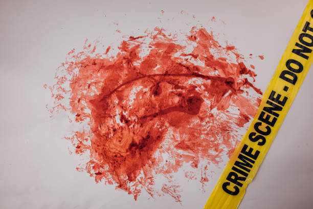 Crime scene tape over blood stain on white background. Top view. Flat lay concept.