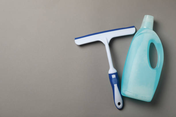 istock Detergent and window cleaning squeegee on gray background 1300360756
