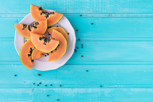 Papaya slices on wooden background. Copy space. Top view.