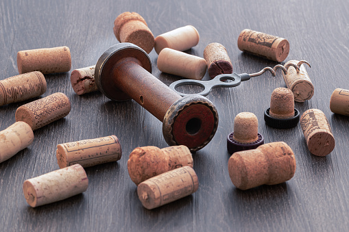 An old corkscrew bottle opener and corks