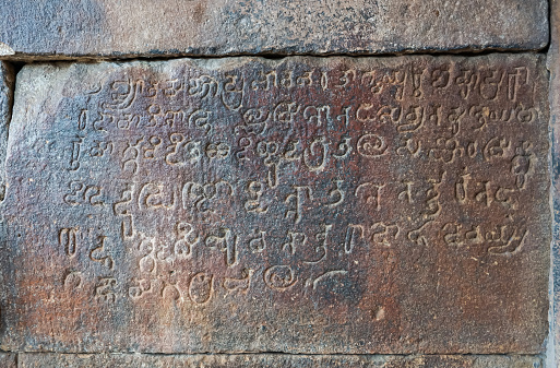 Bagalakote, Karnataka, India - November 7, 2013: Pattadakal temple complex. Closeup of gray stone historic script at entrance to Virupaksha temple.