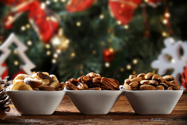 Walnut kernels, brazilian nut and almonds in a bowl on rustic old wooden table