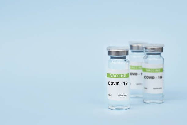 istock Three cans of coronavirus vaccine. on a blue background. copy space, banner 1300362874