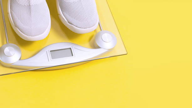 istock Textile sport shoes with weighing scale on yellow 1300364227
