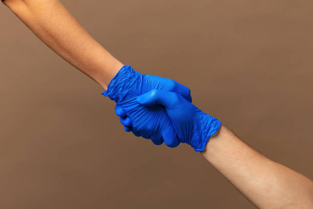 istock Handshake in a blue gloves, help concept. Personal hygiene during a pandemic 1300366476