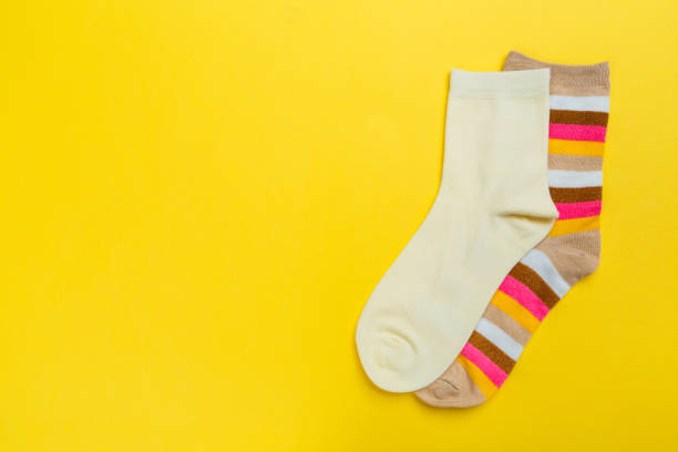 istock Multi-colored socks on a yellow background. View from above. Many different socks for cold seasons 1300366585