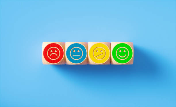 istock Smiley Face Symbols Drawn Colorful Wood Blocks  Sitting on Blue Background 1300367341