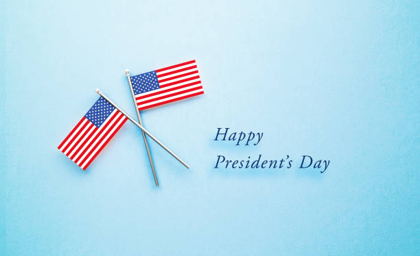 istock President's Day Message Next to Tiny American Flag Pair on Blue Background 1300367904