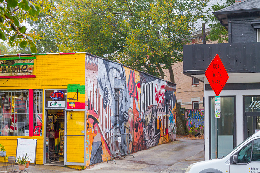 Five Points Neighborhood, Atlanta, Georgia State, USA - 9 October, 2020: A general empty landscape view of shops and restaurants at Little Five Points Neighborhood, in Atlanta, Georgia State. This area is, in those days, very famous for the hippie style a rounded in their graffitis murals, bars, restaurants, coffee shops, tattoo stores, and more. Just a few tourist during the Corona Virus Covid-19 breakdown illness.\n\n\