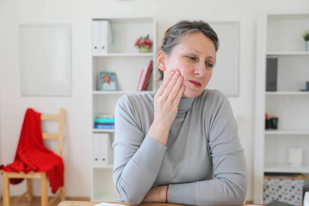 A middle-aged woman with a toothache A middle-aged woman with a toothache relieved face stock pictures, royalty-free photos & images