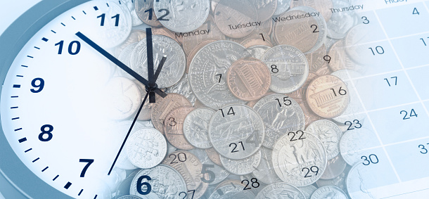 Clock, American coins and calendar. Time is money