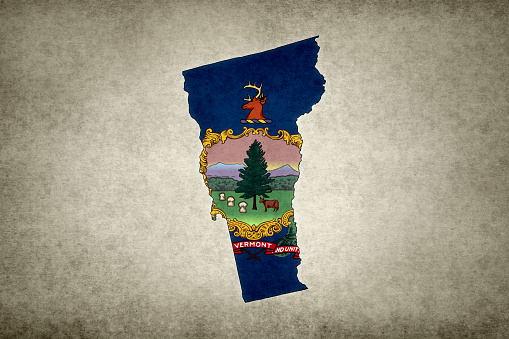 Grunge map of the state of Vermont (USA) with its flag printed within its border on an old paper.