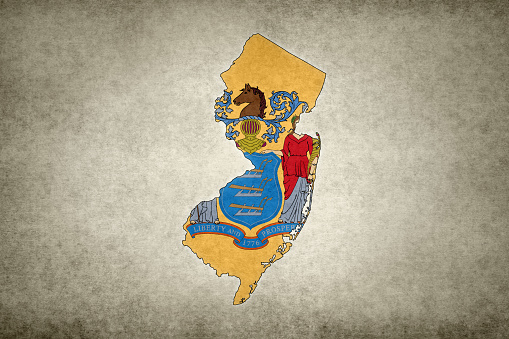 Grunge map of the state of New Jersey (USA) with its flag printed within its border on an old paper.
