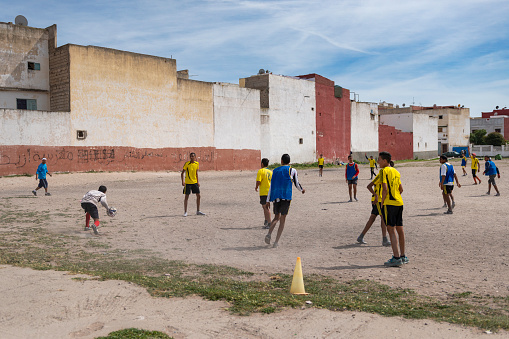 Casablanca, Morocco - April 16, 2016: A group of young boys playing football in an improvised dirt football field, in the outskirts of city of Casablanca.