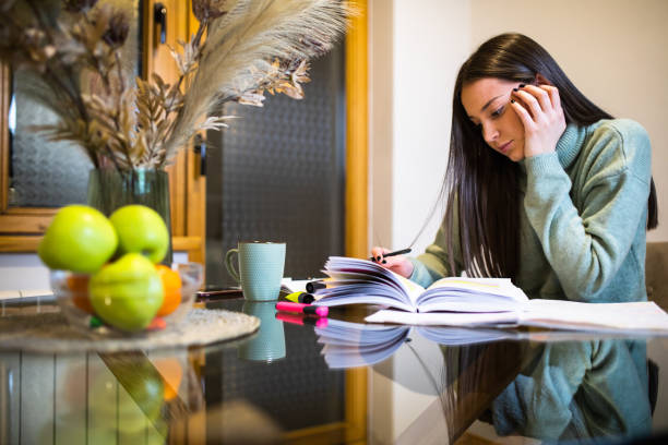 istock A sleepy young woman studying for an exam 1300376135