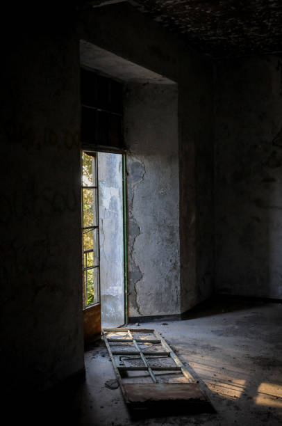 istock Abandoned room broken door and dramatic bright sunlight entering the place 1300378694