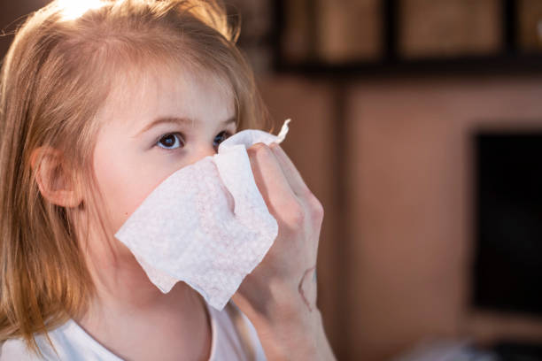 istock Mother wiping daughter's nose with paper tissue 1300381496
