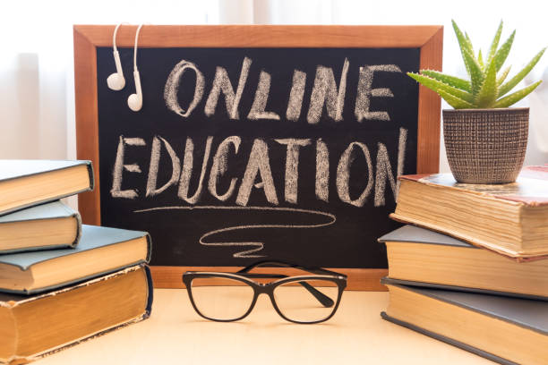 istock Blackboard with text online learning, stack of books glasses. Distance education concept. 1300381498