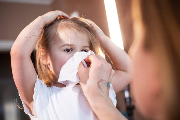 istock Mother wiping daughter's nose with paper tissue 1300381541