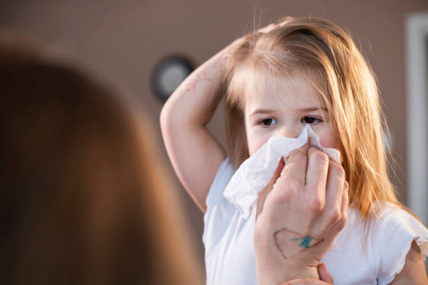 istock Mother wiping daughter's nose with paper tissue 1300381545