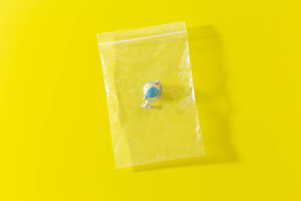 istock little planet Earth in polyethylene plastic disposable bag on yellow 1300382320
