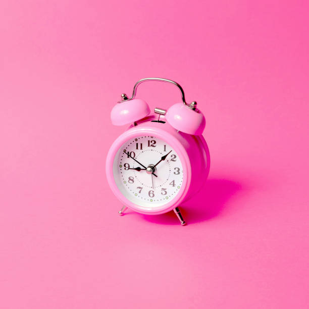 istock Pink alarm clock on a same color background. 1300382561