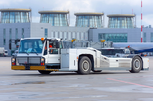 Aerodrome tow tractor is driving along the steering paths at the airport
