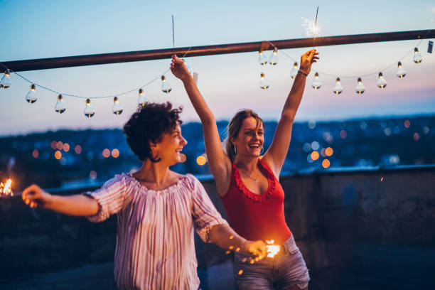 istock Rooftop party friends with sparklers 1300383737