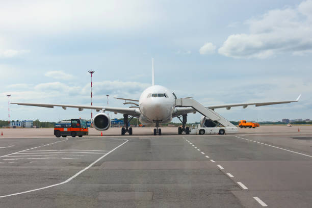 istock Passenger aircraft with boarding stairs, waiting for boarding passengers and baggage before the flight. 1300383912