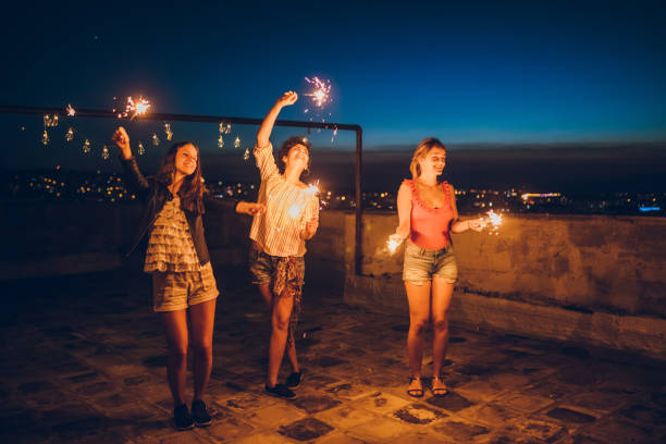 istock Rooftop party friends with sparklers 1300384006