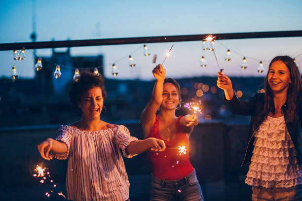 istock Rooftop party friends with sparklers 1300384052