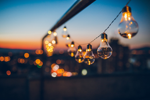 Close up picture of a string light bulbs at sunset on the rooftop.