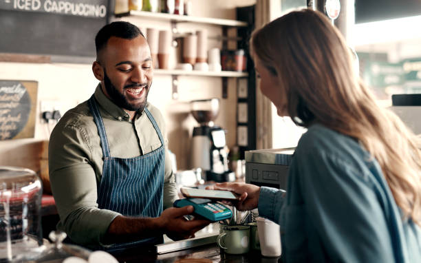 Tap-to-pay technology is so convenient Shot of a young man accepting a digital payment from a customer in a cafe mobile payment photos stock pictures, royalty-free photos & images