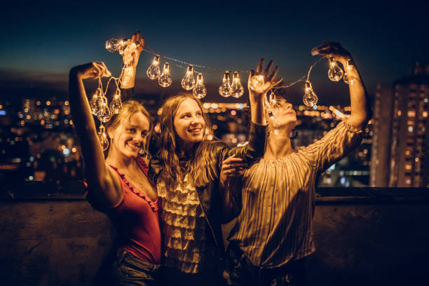istock Three young women hugging on rooftop 1300384738