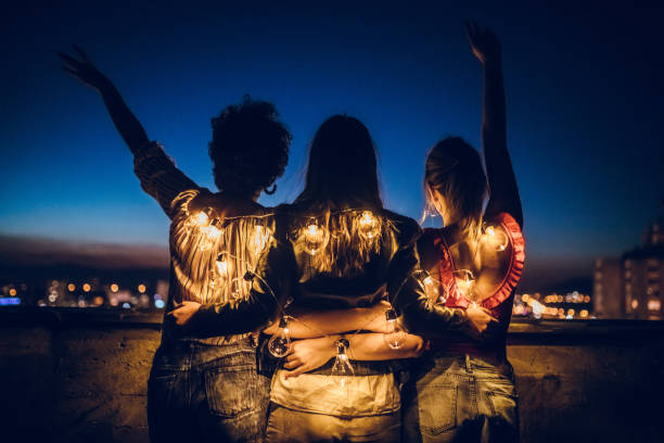 Three young women hugging on rooftop
