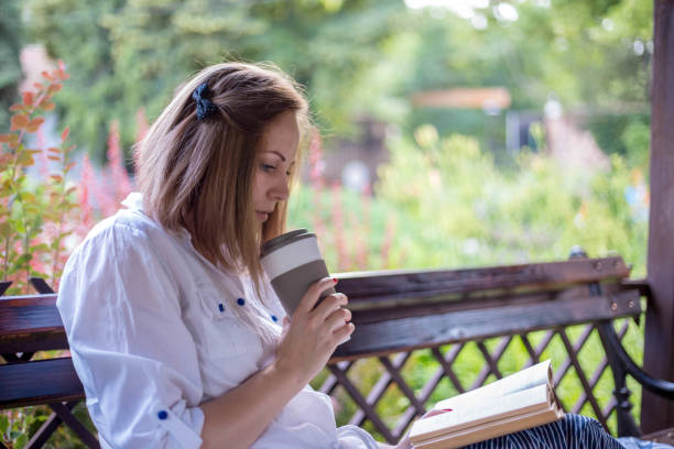 istock Relaxed woman reading book among nature 1300384896