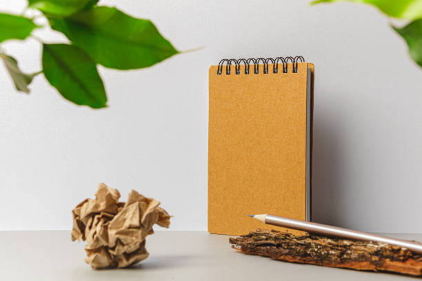 istock Flat lay craft paper card mockup with leaves 1300384897