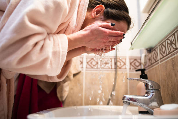 istock A young woman washing her face 1300385762