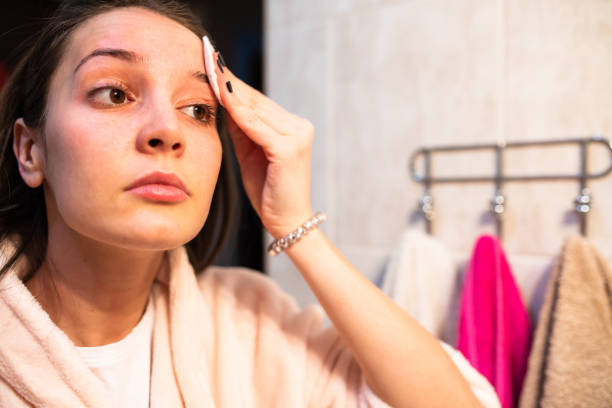 istock A young woman cleansing her face with a cotton pad 1300385788
