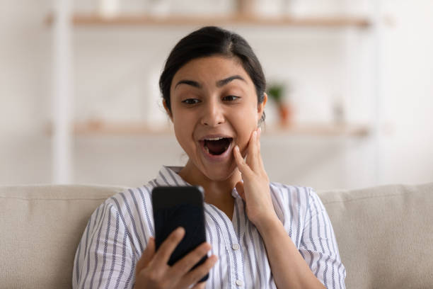 istock Indian female shocked by unexpected pleasant surprise on cellphone screen 1300386334