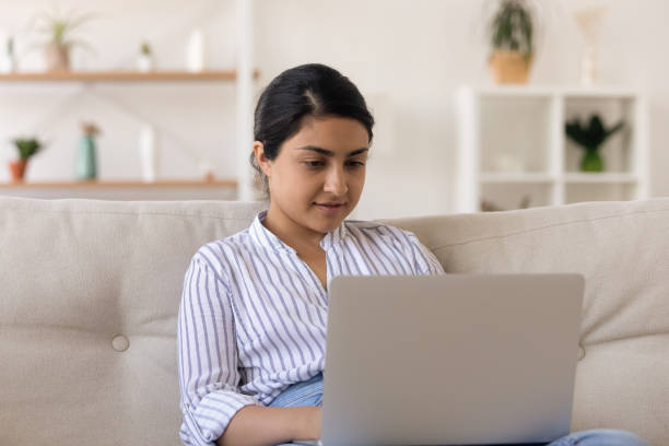 istock Focused mixed race female browse job seeking websites using laptop 1300386347