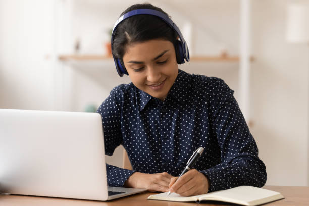 istock Young indian lady wearing headphones practice in distant learning 1300386385