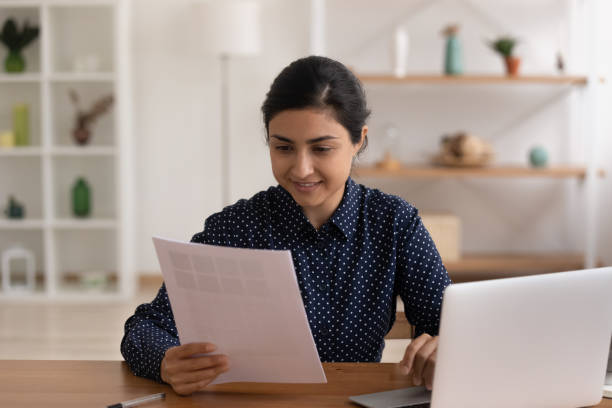 istock Young hindu female freelancer doing paperwork at workplace 1300386391