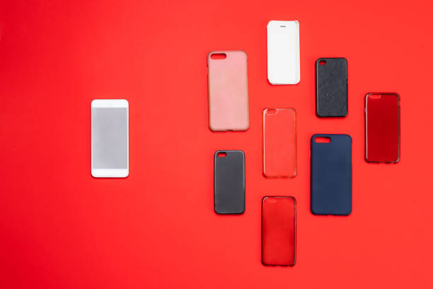istock Choice of multicolored plastic back covers for mobile phones on red background with a smart phone on the side 1300388640
