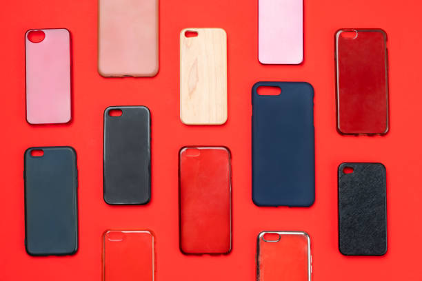 istock Pile of multicolored plastic back covers for mobile phone. Choice of smart phone protector accessories on red background. A lot of silicone phone backs or skins next to each other 1300388643