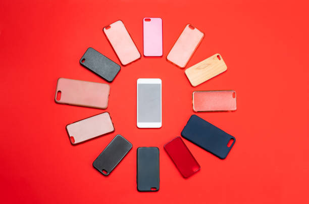 istock Choice of multicolored plastic back covers for mobile phones on red background with a smart phone on the side 1300388668