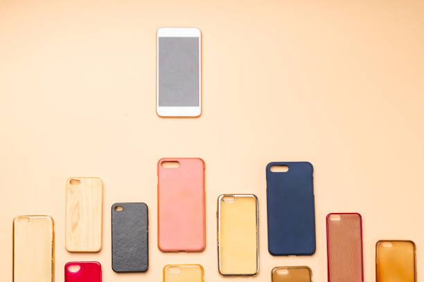 istock Choice of multicolored plastic back covers for mobile phones on neutral background with a smart phone on the side 1300388718